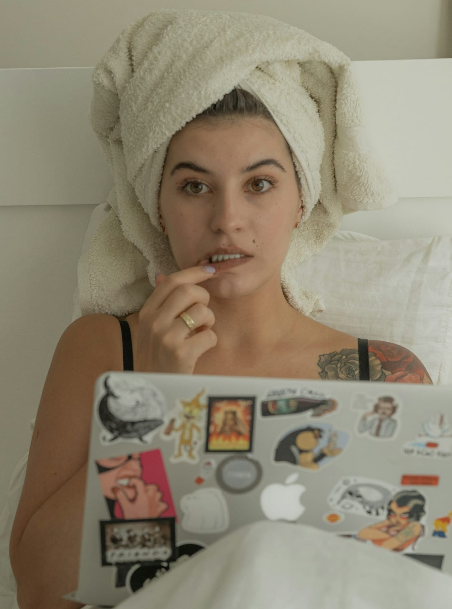 a woman with a towel on her head using a laptop